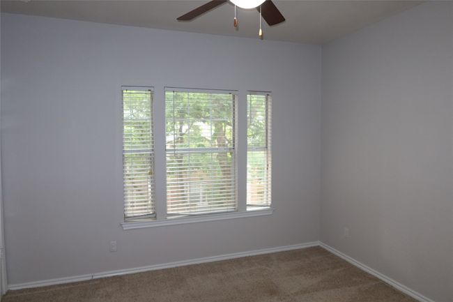 Carpeted spare room featuring ceiling fan and baseboards | Image 17