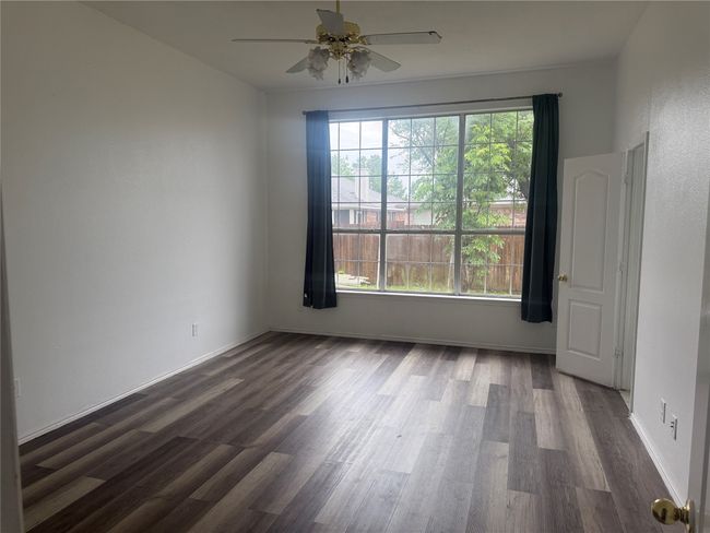 Spare room featuring dark wood finished floors, a healthy amount of sunlight, and ceiling fan | Image 11