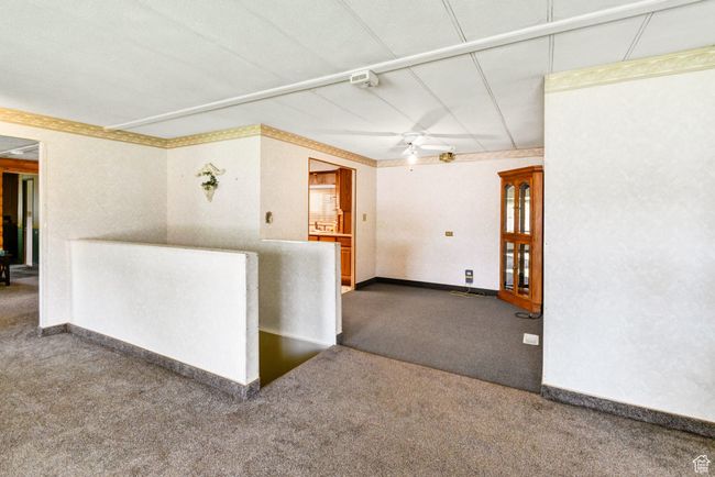 Carpeted spare room featuring a ceiling fan and baseboards | Image 12