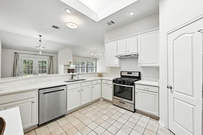 Open and charming kitchen has updated counter tops and stainless appliances | Image 9