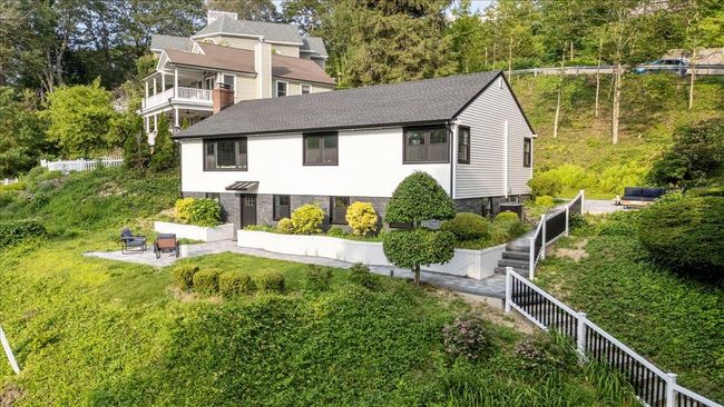 Back of house with a patio area, roof with shingles, and a chimney | Image 36