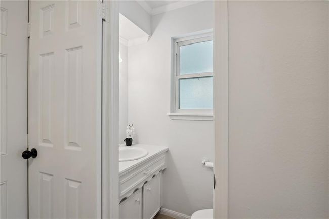 The picturesque half bathroom is cleverly located in the laundry-room coming in from the garage, and discreetly close to the kitchen. | Image 20