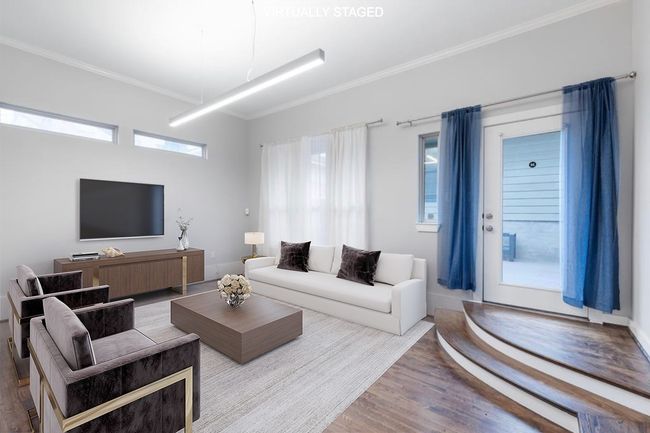 Living area with wood finished floors and crown molding | Image 23