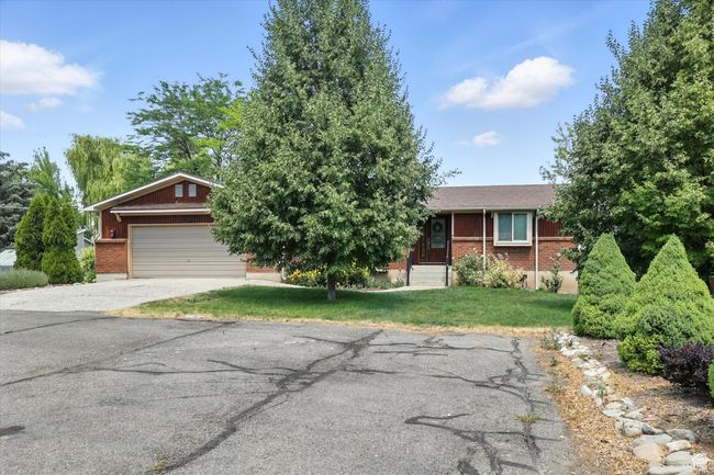 View of front of property featuring brick siding, concrete driveway, a front yard, and an attached garage | Image 4