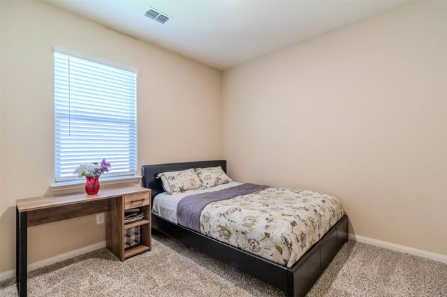 Bedroom with light colored carpet and multiple windows | Image 17