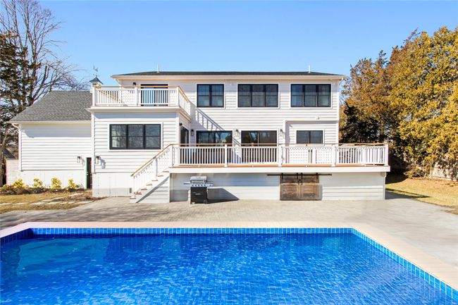 Back of property with stairway, a patio area, a balcony, and an outdoor pool | Image 23