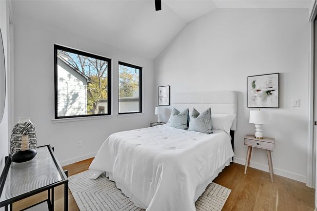 Bedroom with light wood-type flooring, vaulted ceiling, and ceiling fan | Image 12