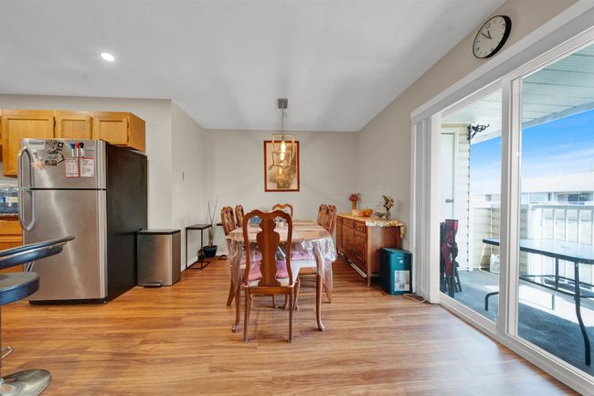 Kitchen with stainless steel appliances, light wood-style floors, a sink, a peninsula, and exhaust hood | Image 6