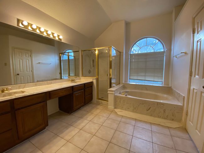 Bathroom with tile patterned flooring, a bath, double vanity, a stall shower, and vaulted ceiling | Image 18