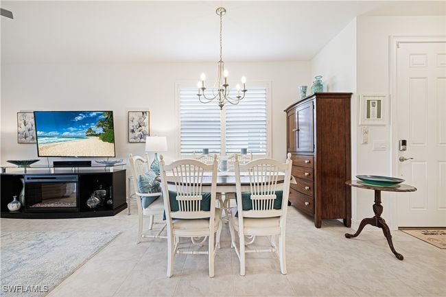 Dining room with a chandelier and light tile patterned flooring | Image 15