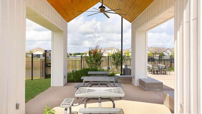 Fenced backyard with outdoor dining area, a patio area, a ceiling fan, and a residential view | Image 9
