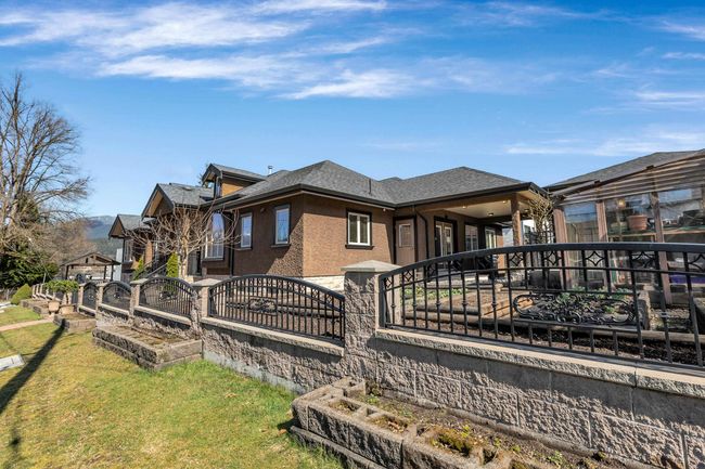 View of property exterior featuring a shingled roof and stucco siding | Image 4