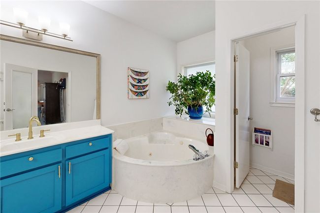 Bathroom featuring tile patterned floors, a jetted tub, and vanity | Image 18