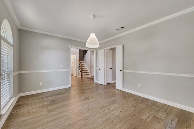 Empty room featuring crown molding, light wood-type flooring, and stairs | Image 6