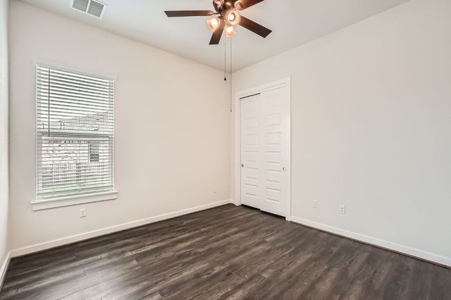 Spare room with a ceiling fan, dark wood-style flooring, and baseboards | Image 19