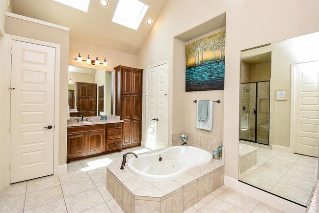 This spa-like bath is the perfect place to unwind and relax! No stress allowed here! Soak in your whirlpool tub with skylights overhead! The tub has a retractable hand sprayer as well! Tile floors, recessed lights and a fulll length dressing mirror. | Image 26