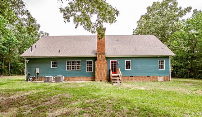 Back of property with crawl space, central AC, a chimney, and a lawn | Image 37