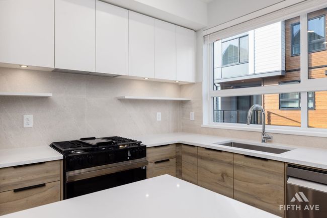Kitchen with black range with gas cooktop, dishwasher, modern cabinets, and decorative backsplash | Image 17