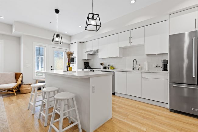 Kitchen featuring tasteful backsplash, a center island, a sink, appliances with stainless steel finishes, and under cabinet range hood | Image 6