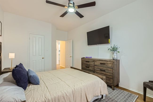Bedroom with wood finished floors, a ceiling fan, and lofted ceiling | Image 19