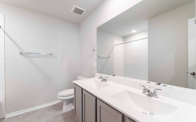 Full bath featuring double vanity, a tile shower, and tile patterned flooring | Image 13