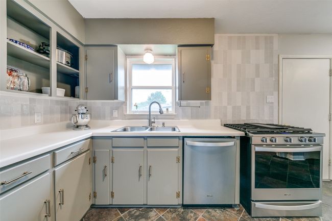 Kitchen featuring appliances with stainless steel finishes, gray cabinetry, and tasteful backsplash. | Image 10