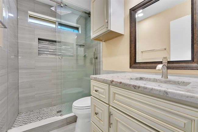 Bathroom featuring walk in shower, vanity, and toilet | Image 18
