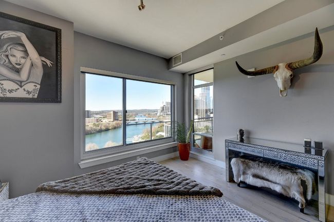 Bedroom featuring wood finished floors, a water view, and baseboards | Image 6
