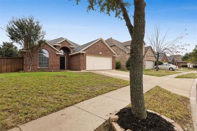 View of front facade with a garage and a front yard | Image 1