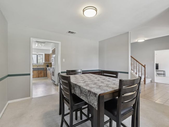 Dining space featuring visible vents, stairway, light tile patterned flooring, and light carpet | Image 7