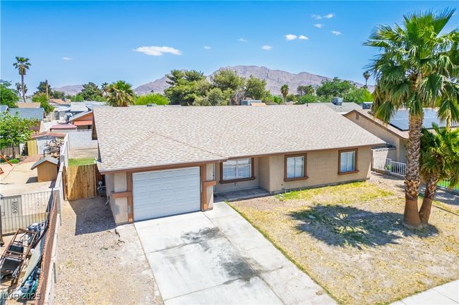 Ranch-style home featuring stucco siding, a mountain view, and an attached garage | Image 25