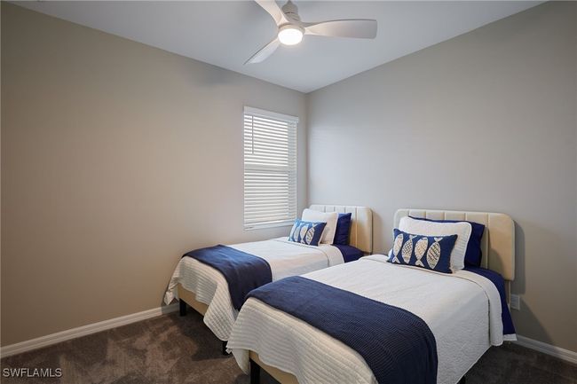 Bedroom with ceiling fan, dark carpet, and baseboards | Image 12