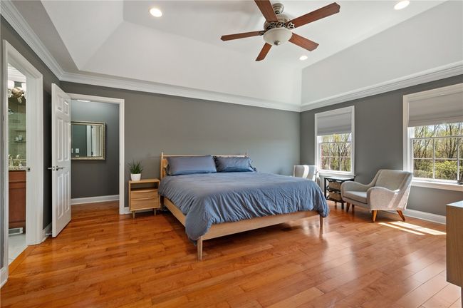 Primary bedroom with hardwood floors tray ceiling double closet and walk in attic area | Image 23