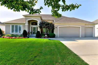 View of front facade with a front yard and a garage | Image 1