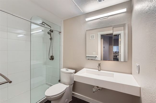 Bathroom with tiled shower and a textured wall | Image 9