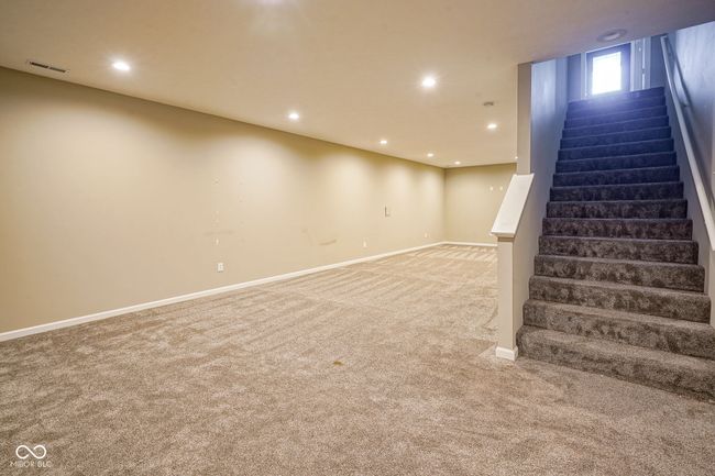 basement with light carpet, stairs, and recessed lighting | Image 34