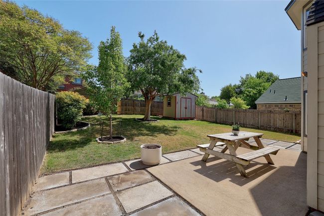 View of patio with a storage shed, a fenced backyard, an outdoor structure, and outdoor dining area | Image 24