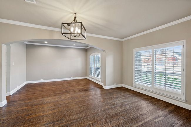 Unfurnished dining area featuring ornamental molding, dark wood-type flooring, and a chandelier | Image 26