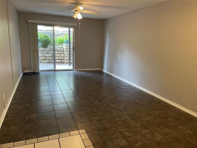 Unfurnished room featuring ceiling fan and dark tile patterned flooring | Image 6