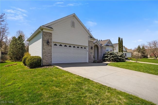Ranch-style house with brick siding, a front yard, concrete driveway, and a garage | Image 4
