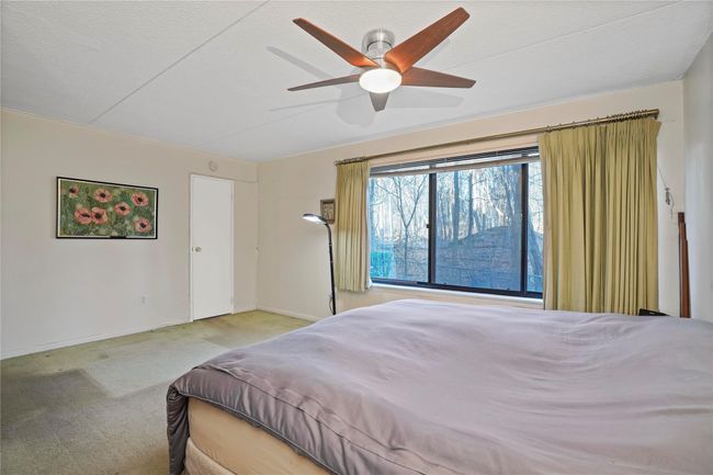 Bedroom featuring a textured ceiling, ceiling fan, and light colored carpet | Image 22