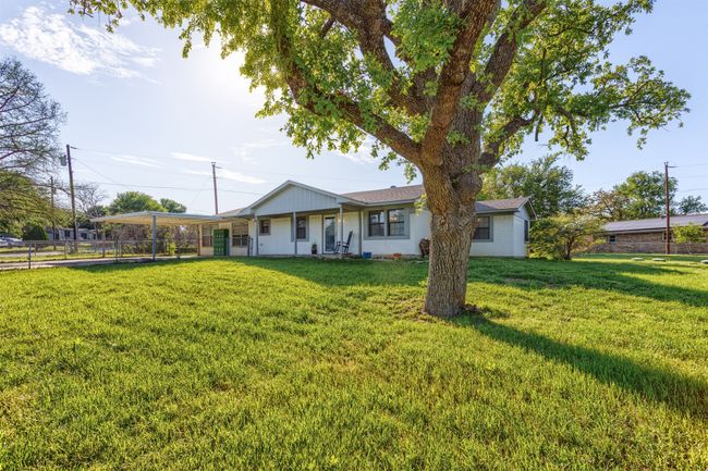 Back of property with a lawn, a carport, and fence | Image 29