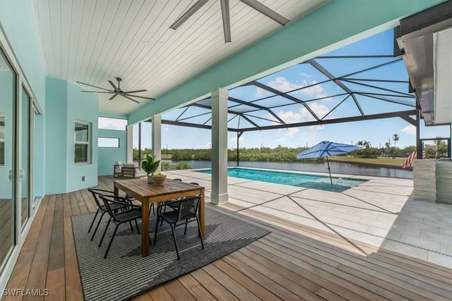 Outdoor pool with ceiling fan, outdoor dining area, a patio, and a deck with water view | Image 31