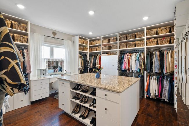 Enormous custom walk-in closet with built-ins and center island with private access to the laundry room. | Image 20