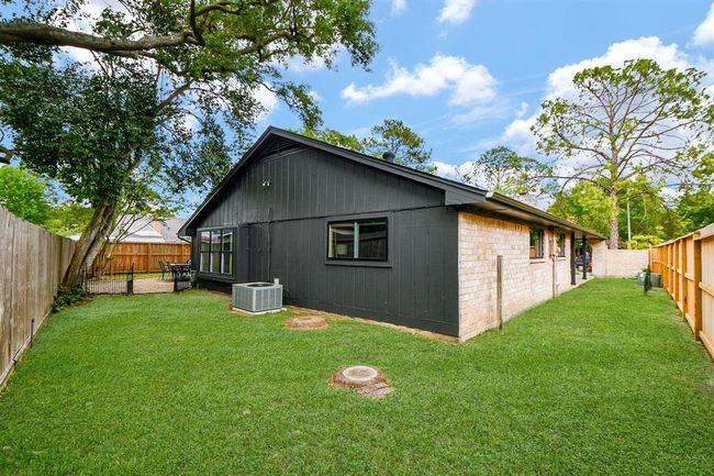 Charming single-story home with a modern black and brick exterior, set on a spacious, well-maintained lawn. The backyard is fenced, providing privacy and includes a patio area for outdoor relaxation. Ideal for families seeking a cozy and stylish living space. | Image 46