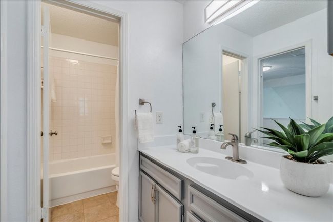 Full bathroom with vanity, toilet, tile patterned floors, and shower / washtub combination | Image 27