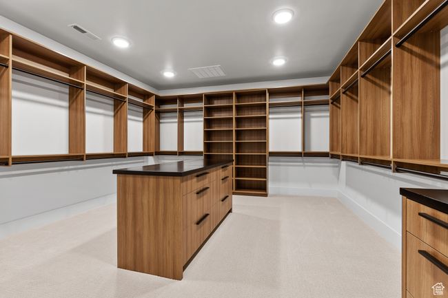 Walk in closet with visible vents and light colored carpet | Image 39
