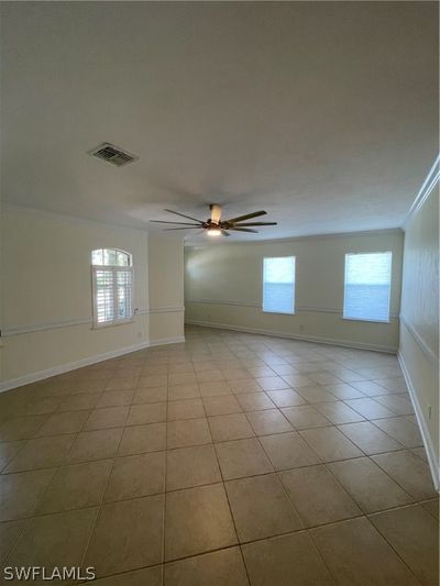 Tiled spare room featuring ornamental molding and ceiling fan | Image 3