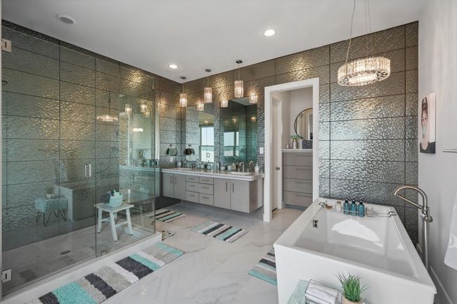 Bathroom with tile walls, a shower stall, an inviting chandelier, and a freestanding bath | Image 29