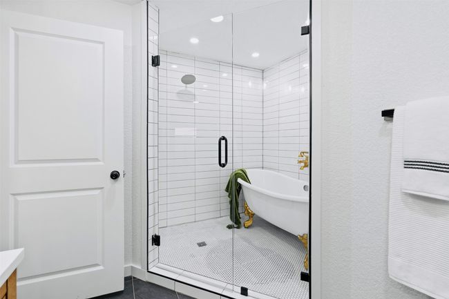 Full bathroom featuring a freestanding tub, a stall shower, vanity, tile patterned flooring, and recessed lighting | Image 19
